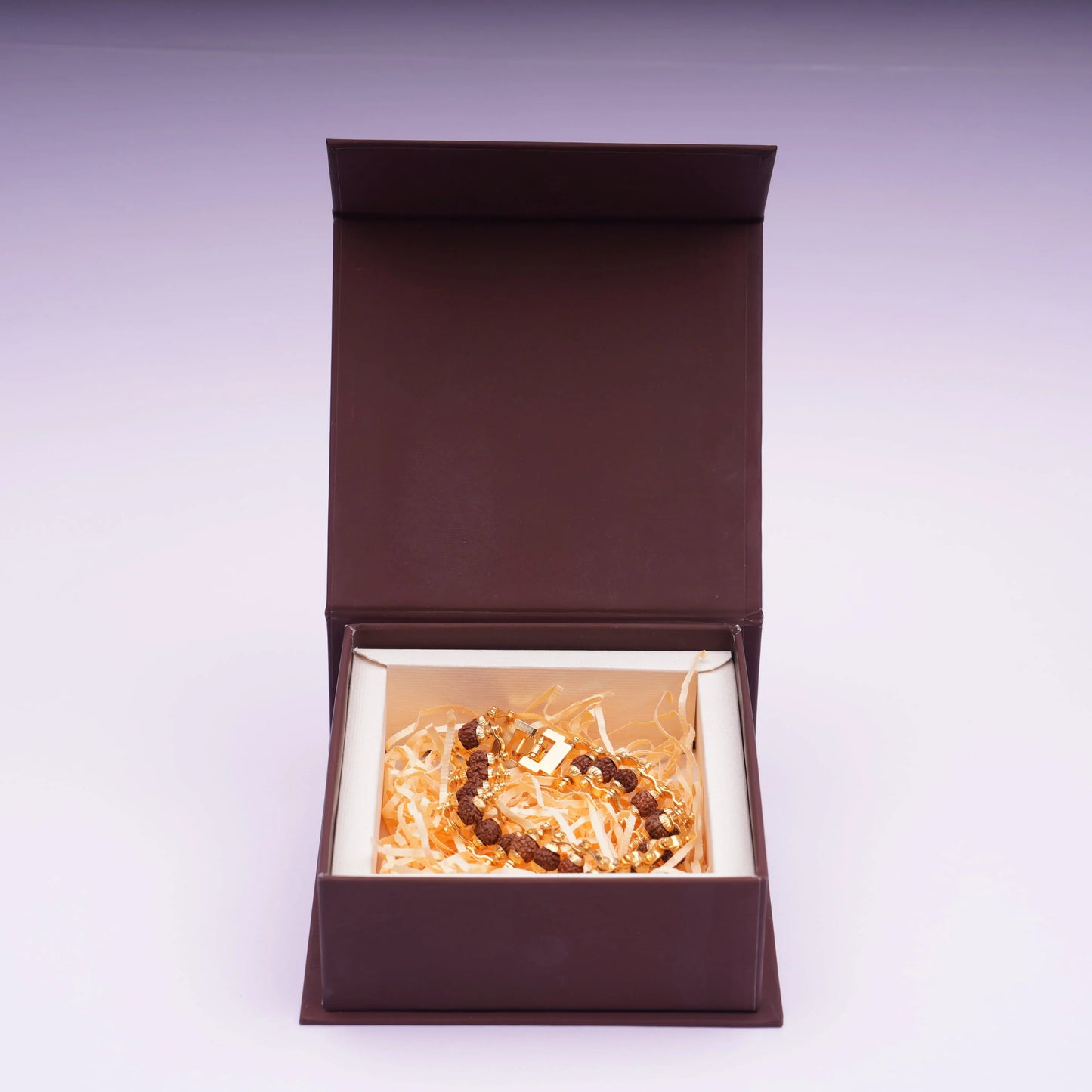 Brown beaded gemstone bracelet in gift box with shredded paper filler