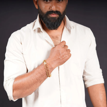 Man in white shirt wearing gold-toned stone bracelet on wrist against dark background