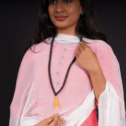 Woman wearing black stone mala necklace with yellow tassel over pink and white kurta