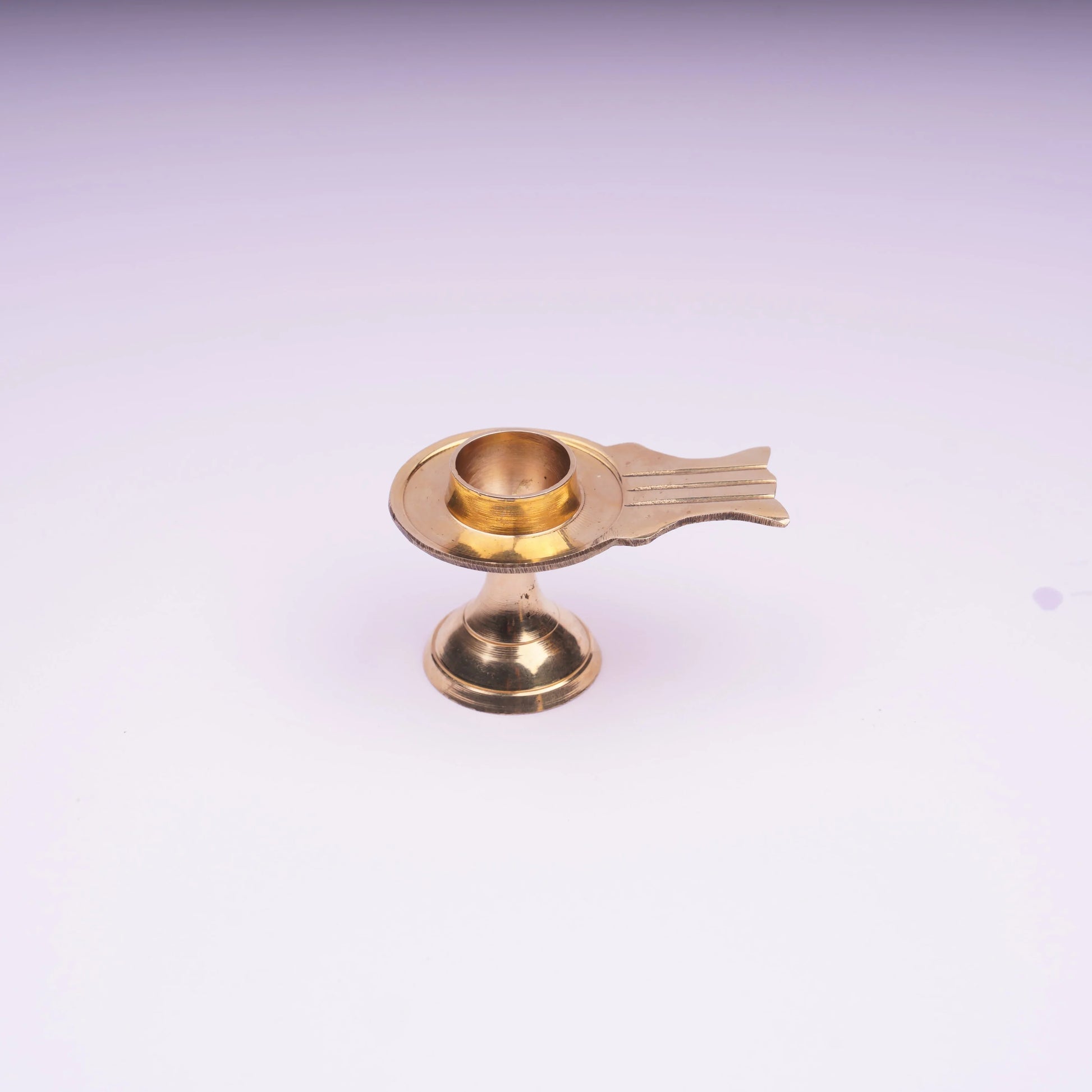 Brass oil lamp with pedestal base on white background, traditional decor item