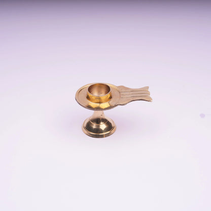 Brass oil lamp with pedestal base on white background, traditional decor item