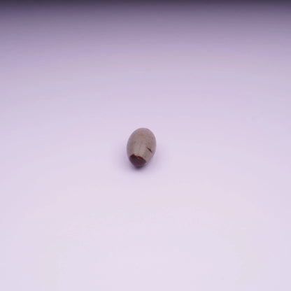 Single polished oval stone on white background, minimalist product photo