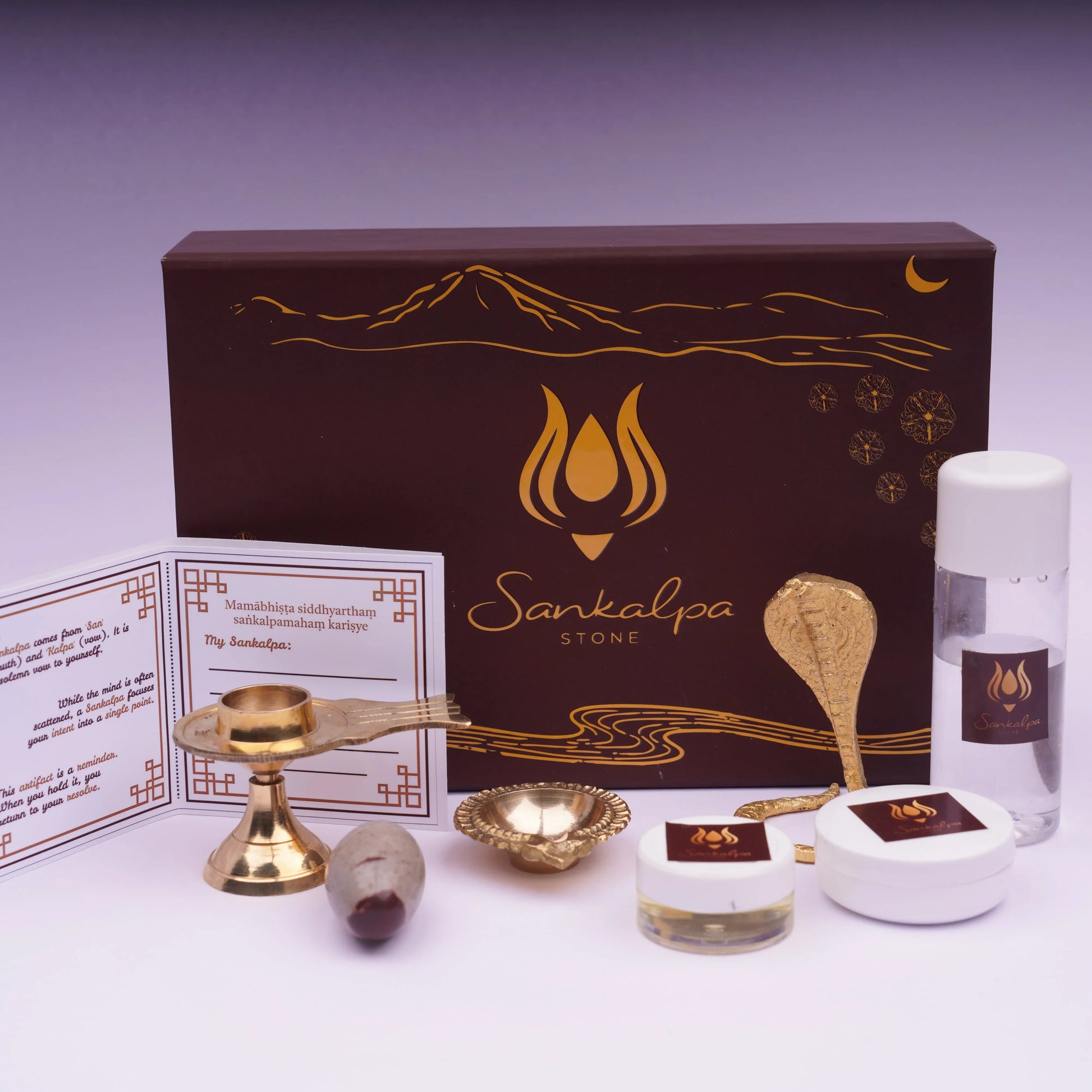 Spiritual ritual kit with brass items, stone, containers, card, and Sankalpa Stone box