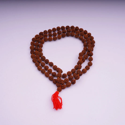Rudraksha prayer mala beads with red tassel on white background