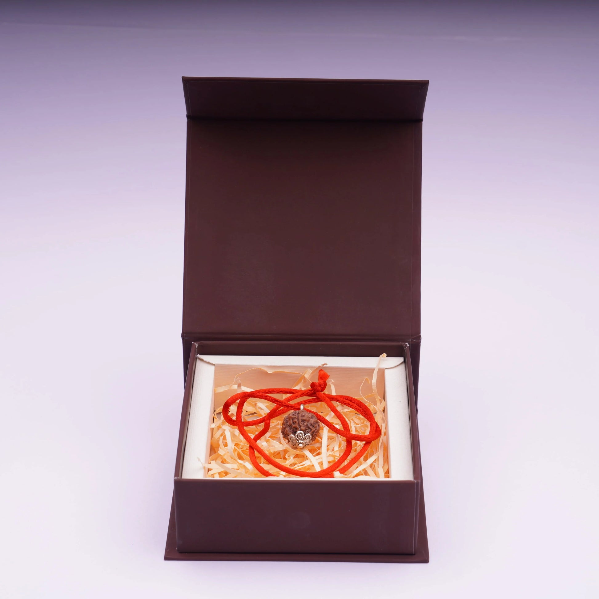 Five Mukhi Rudraksha pendant with red thread in a brown gift box