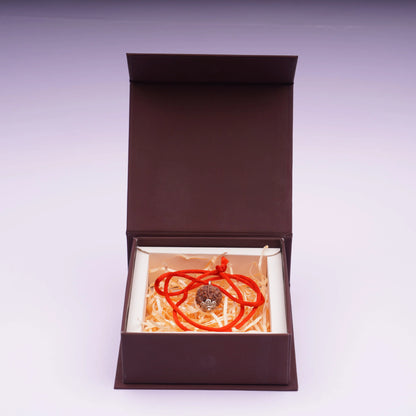 Five Mukhi Rudraksha pendant with red thread in a brown gift box